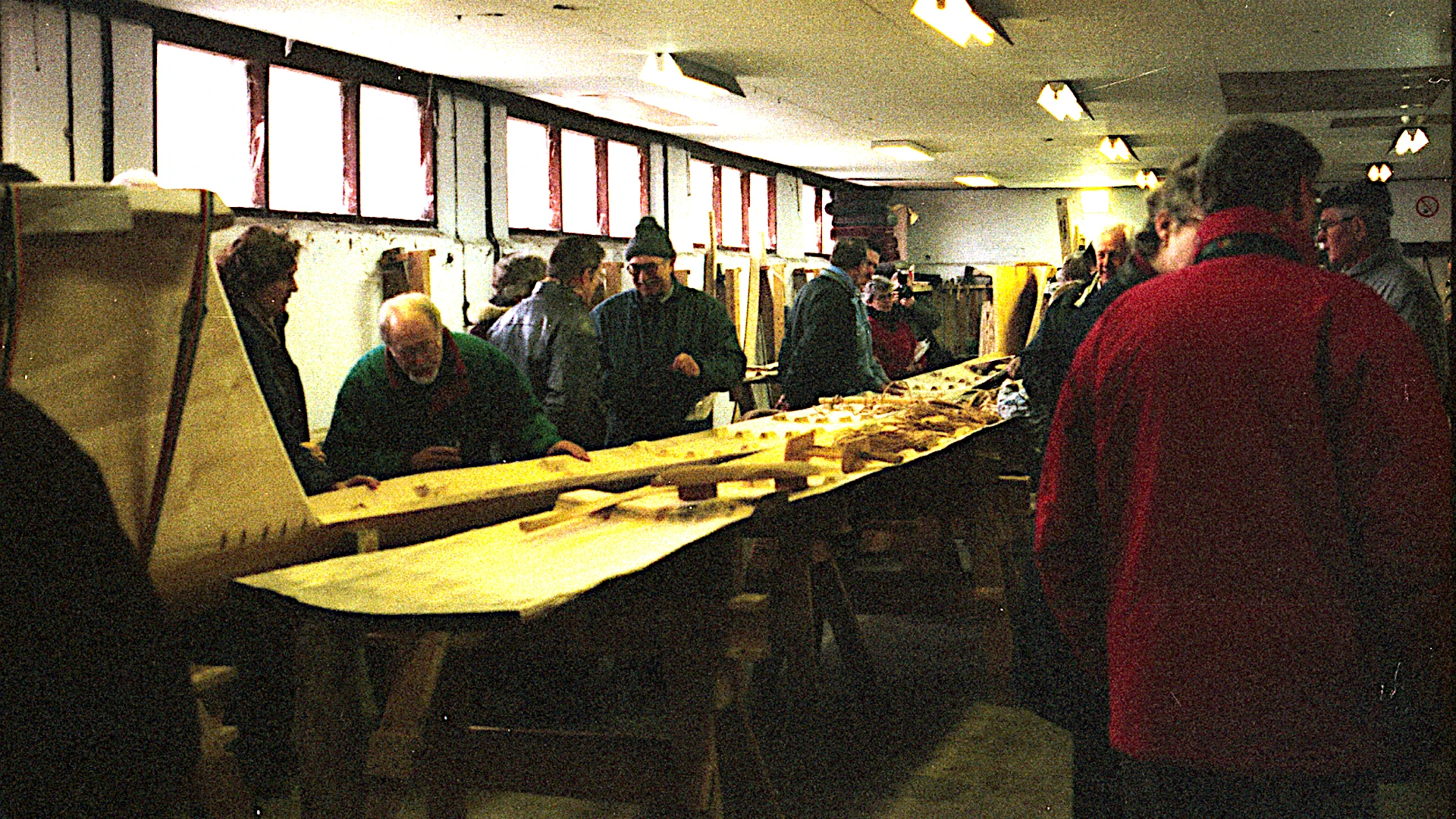 The bottom plank (on the left) is finished and with bow blocks being attached. A side plank has also been made. <br>We held a small party to celebrate this milestone - the keel stretch. Hence the many people.